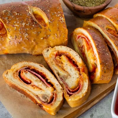 Slices of Stromboli next to pizza sauce.