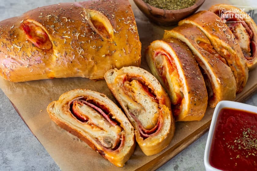 Slices of Stromboli next to pizza sauce.