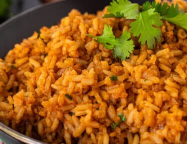 Bowl of Mexican Rice with Cilantro garnished on top.