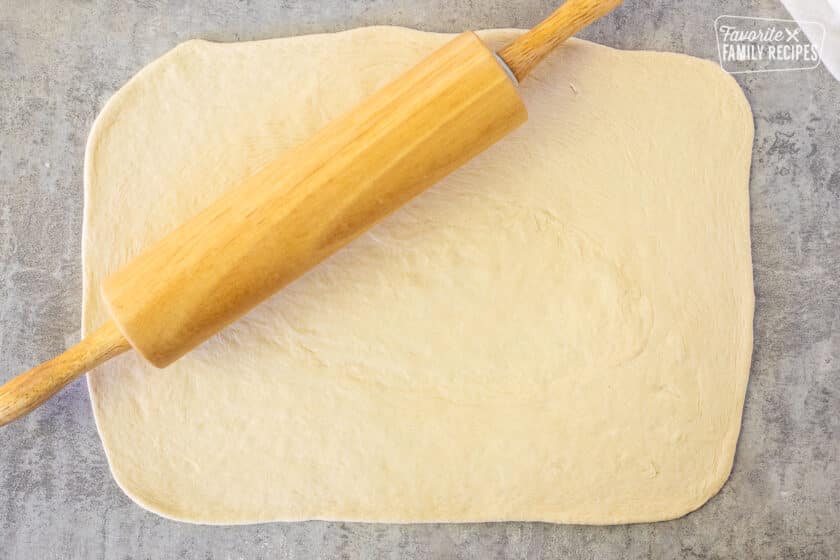 Rolled out dough into rectangle shape with rolling pin.