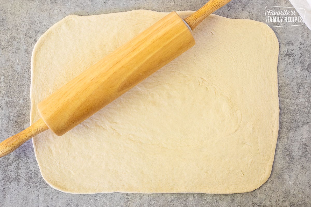 Rolled out dough into rectangle shape with rolling pin.