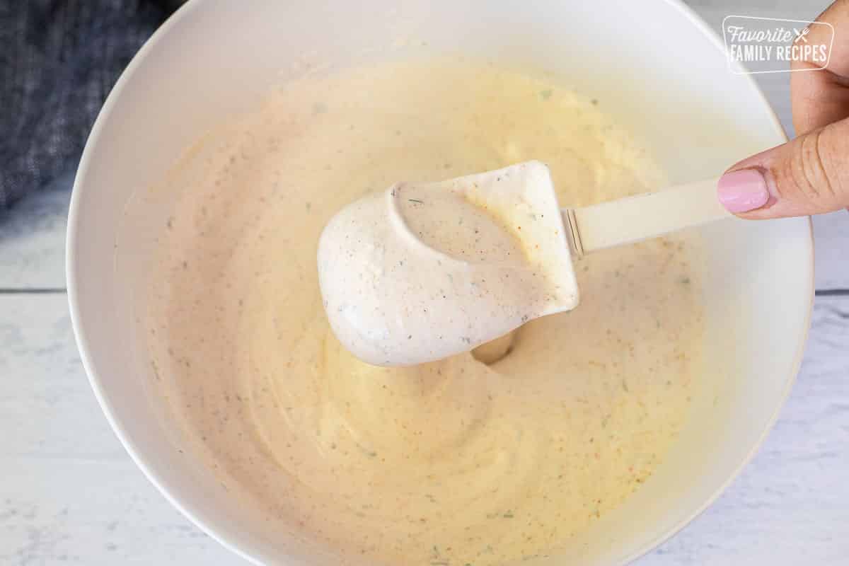 Holding up a spatula with combined veggie dip.