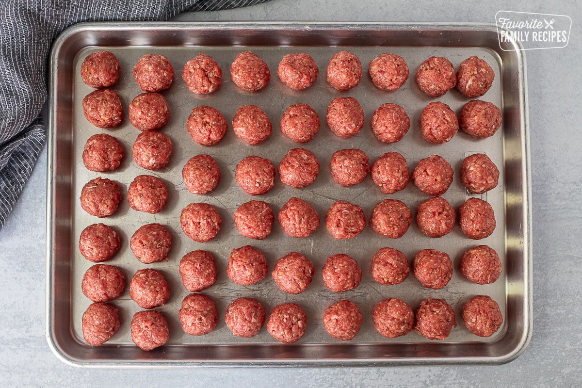 Rolled meatballs on a baking sheet.