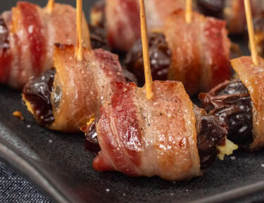 Bacon Wrapped Dates Appetizer with toothpicks on a platter.