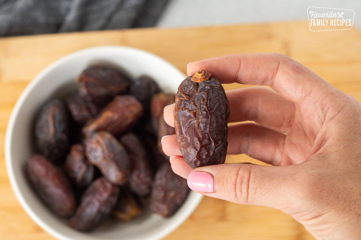 Hand holding a medjool date.