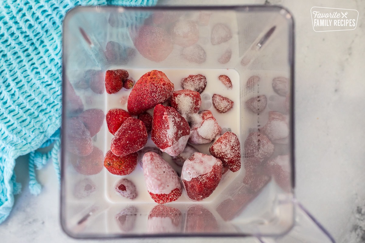 Blender with frozen strawberries, coconut milk and sugar.