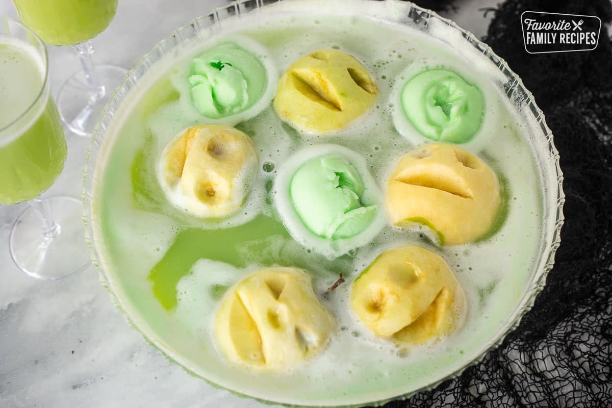 Punch bowl of Halloween drink with apple heads and green lime sherbet.