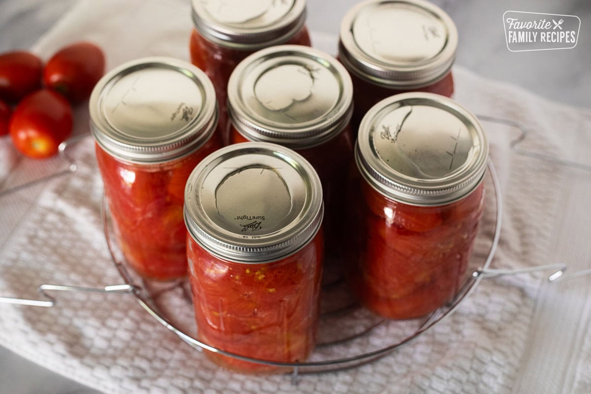 Canning jars in a rack on a towel.