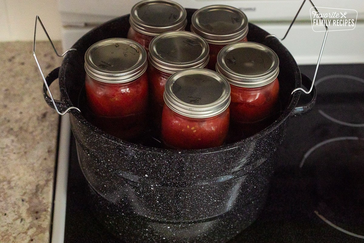 Jars held up by canning rack on a canning pot.