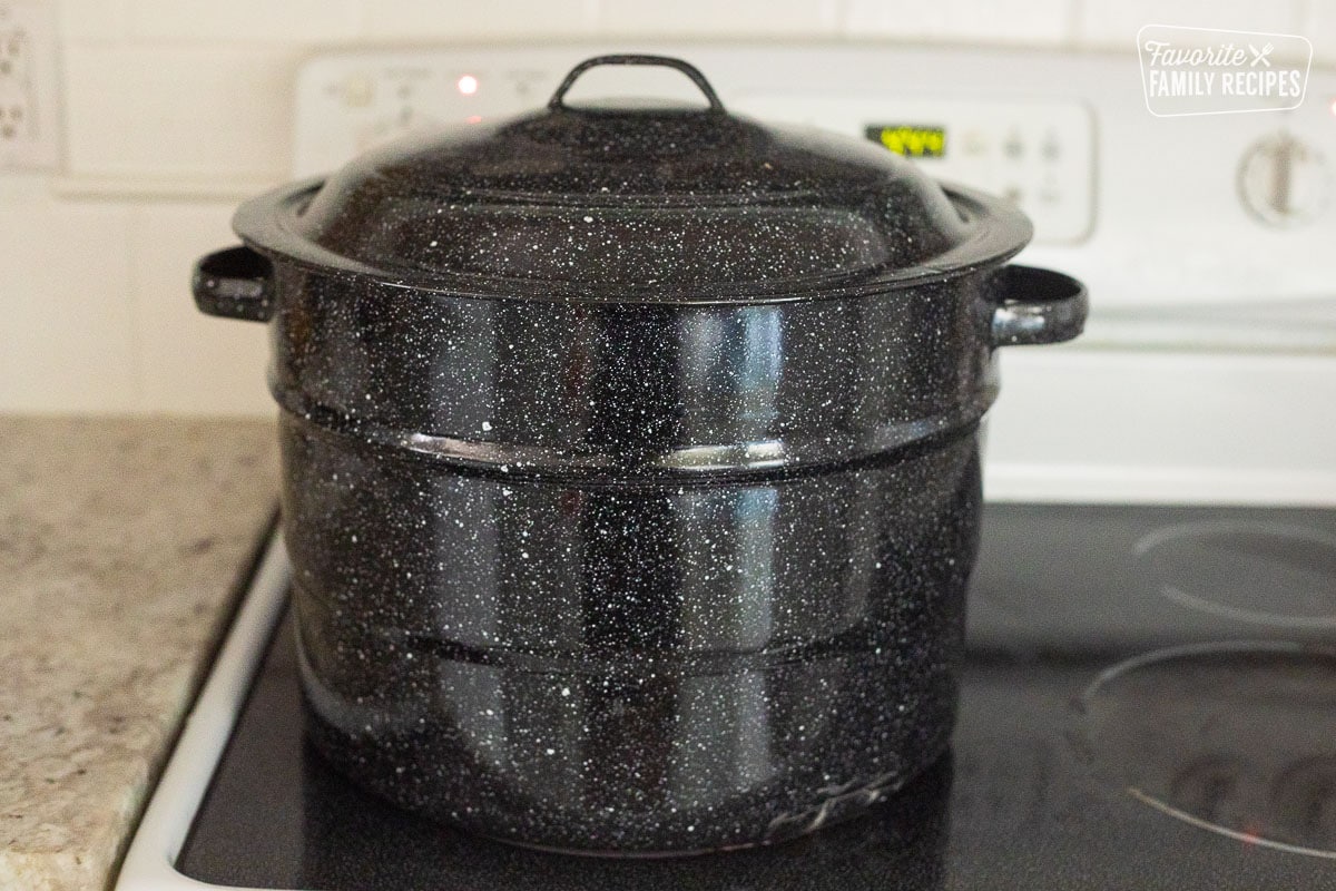 Canning pot with lid on a stovetop.