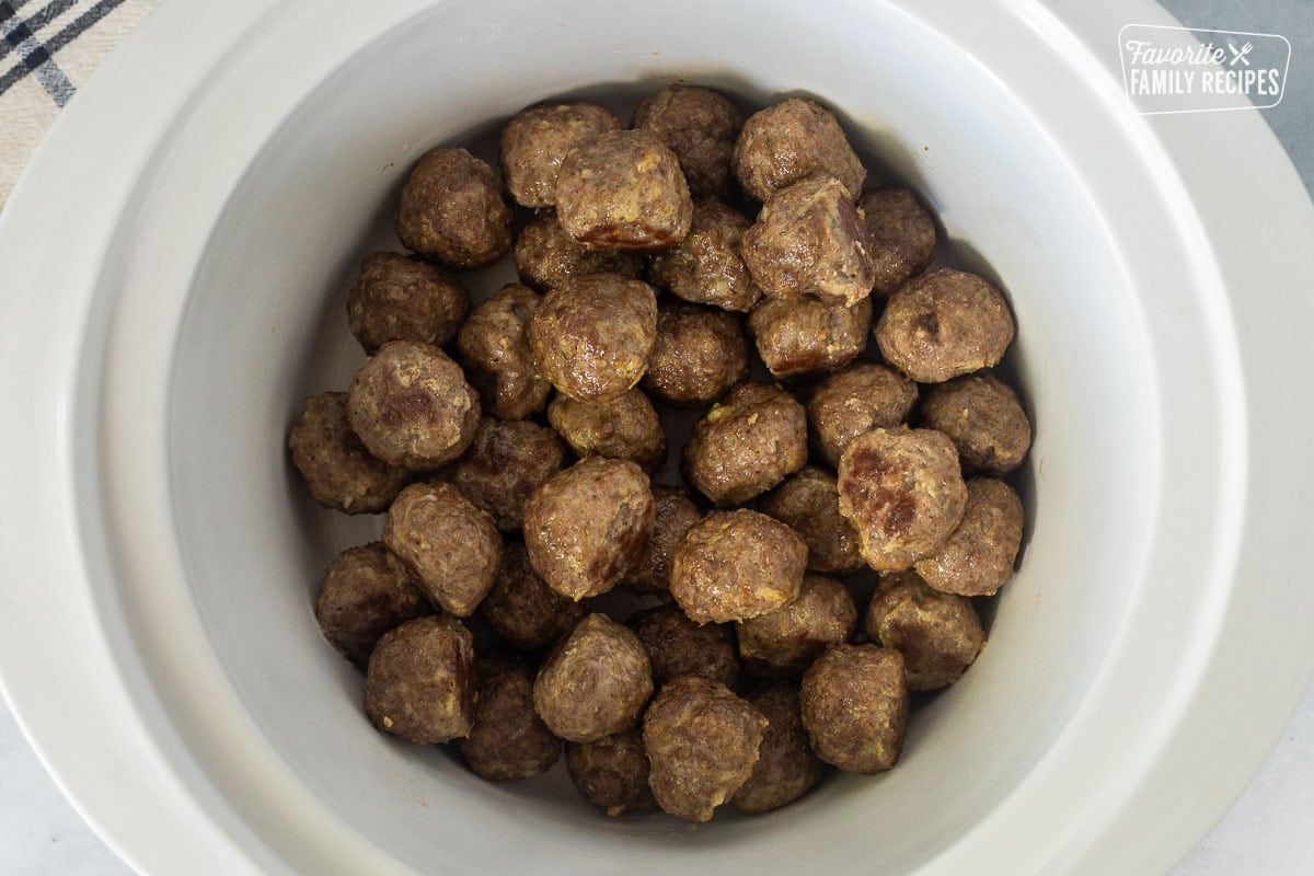 Crock pot with browned meatballs.