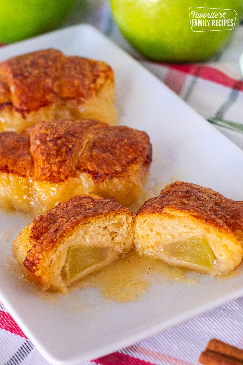 Three Apple Dumplings on a plate with the front one cut in half.