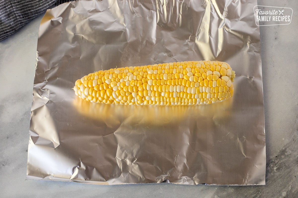 Cob of corn on a piece of foil.