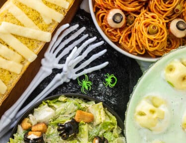 Halloween Dinner with spaghetti and eyeballs, spider Cesar salad, mummy garlic bread and shrunken head green punch.