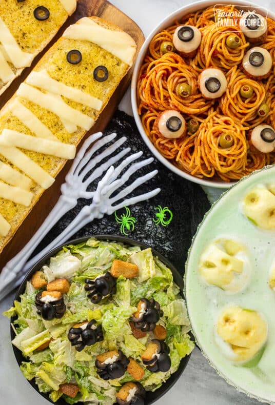 Halloween Dinner with spaghetti and eyeballs, spider Cesar salad, mummy garlic bread and shrunken head green punch.