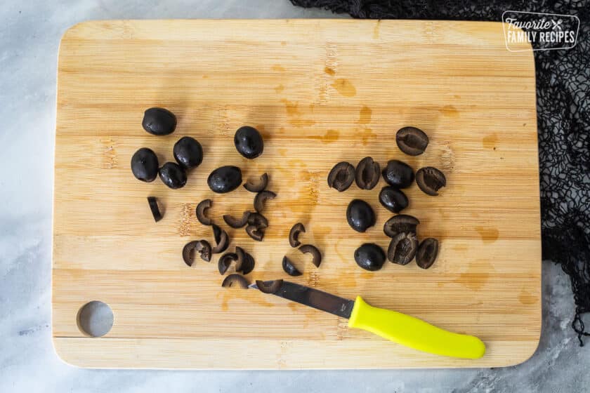 Cutting board with cut olives for spiders.