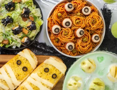 Halloween Dinner with spaghetti and eyeballs, spider Cesar salad, mummy garlic bread and shrunken head green punch.