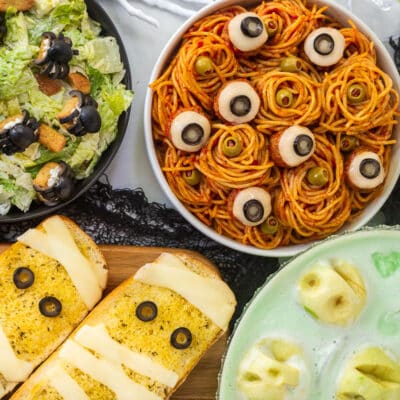 Halloween Dinner with spaghetti and eyeballs, spider Cesar salad, mummy garlic bread and shrunken head green punch.