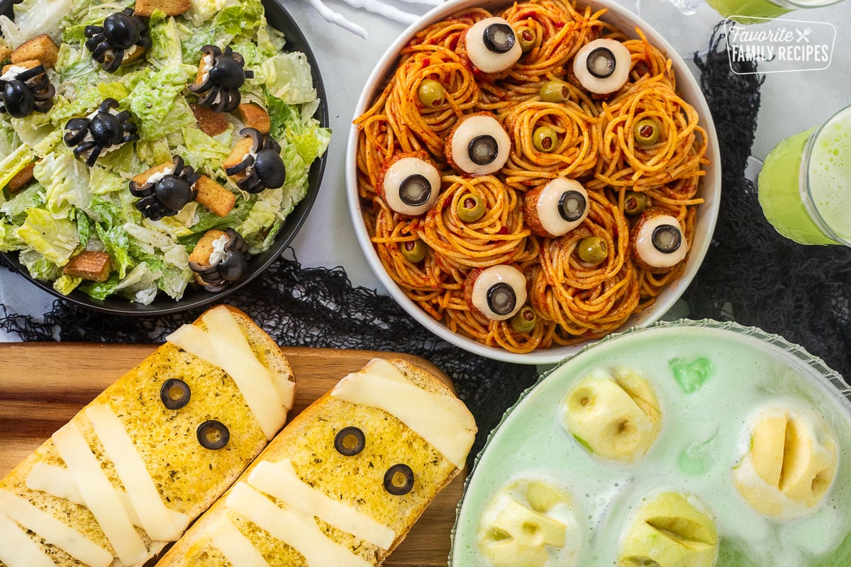 Halloween Dinner with spaghetti and eyeballs, spider Cesar salad, mummy garlic bread and shrunken head green punch.