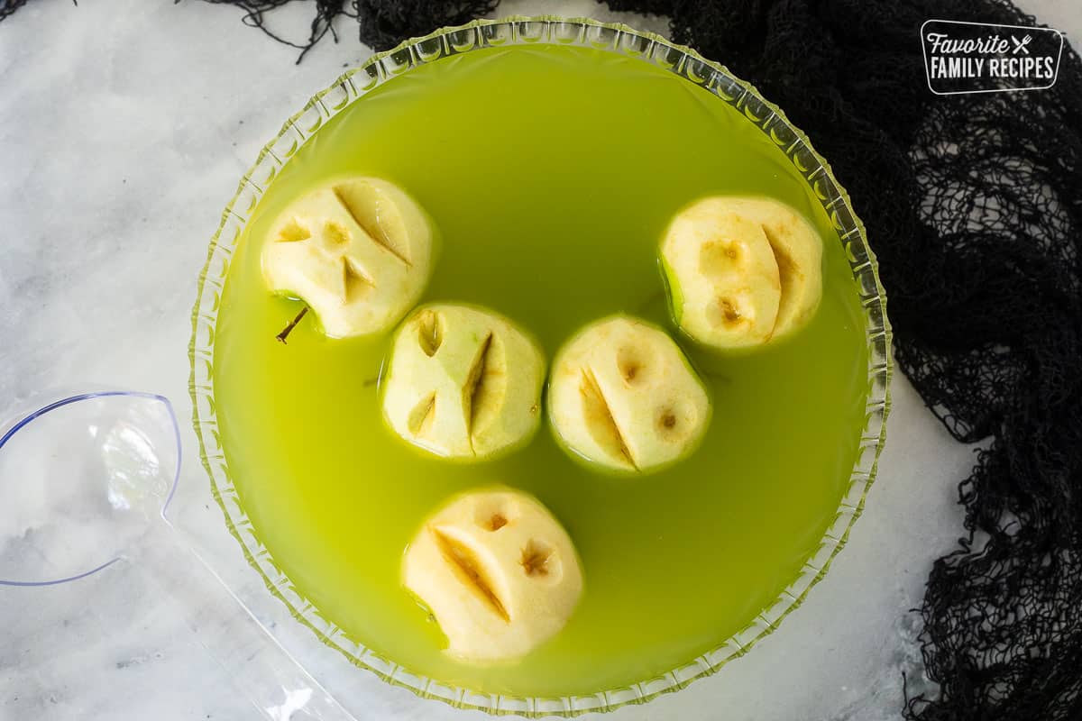 Apple heads floating in punch bowl.