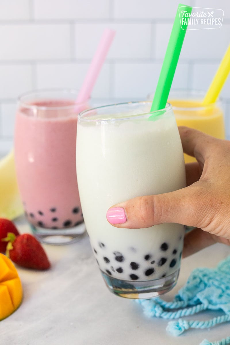 Hand holding a honeydew boba smoothie.