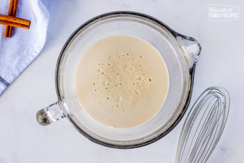 Yeast and water in a mixing bowl for Homemade Cinnamon Rolls.