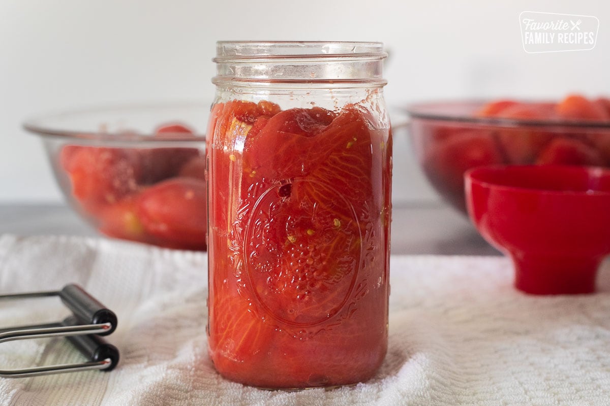 Canning jar with whole tomatoes.