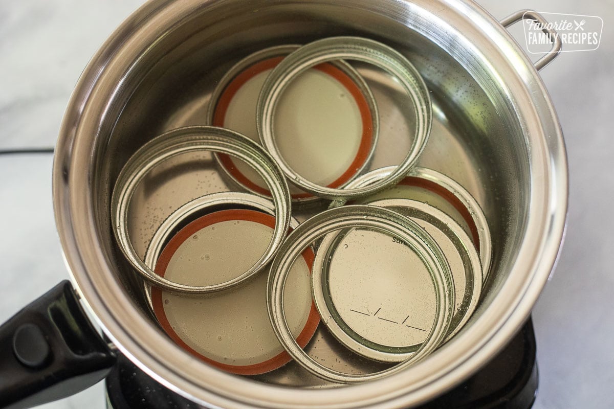 Pan of lids and rims in water.