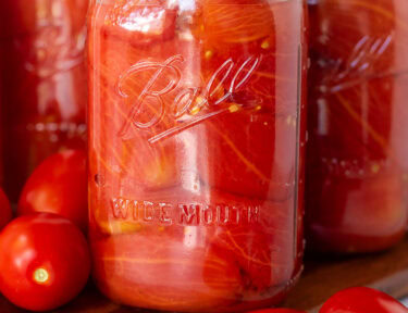 Canning jars of whole tomatoes.