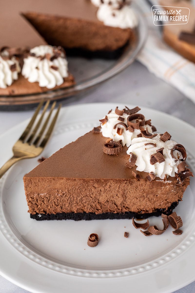 Slice of Chocolate Satin Pie on a plate with extra chocolate curls on the side.