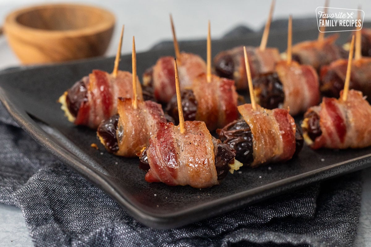 Bacon wrapped dates on a platter.