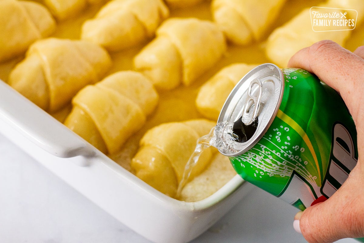 Soda pouring into corners of baking dish for Apple Dumplings.