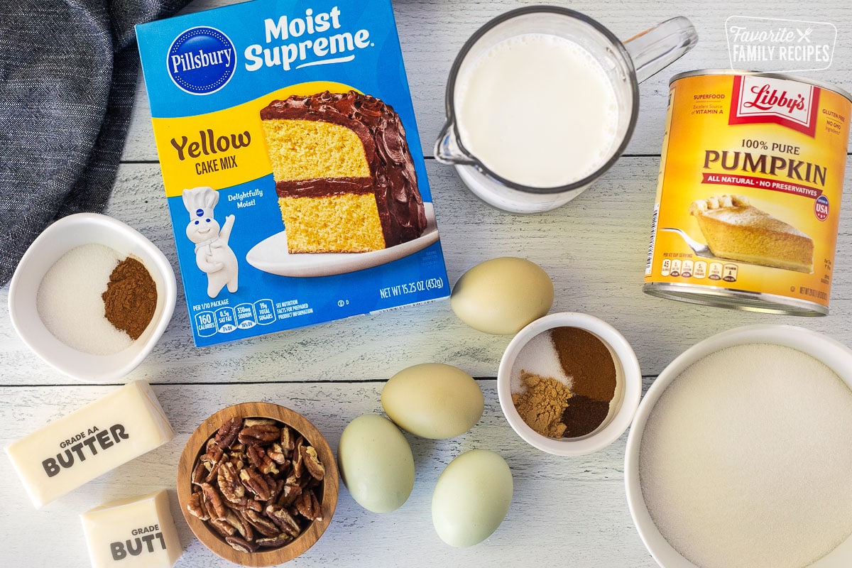 Ingredients to make Pumpkin Cobbler including yellow cake mix, half and half, pure pumpkin, sugar, spices, eggs, pecans, butter.