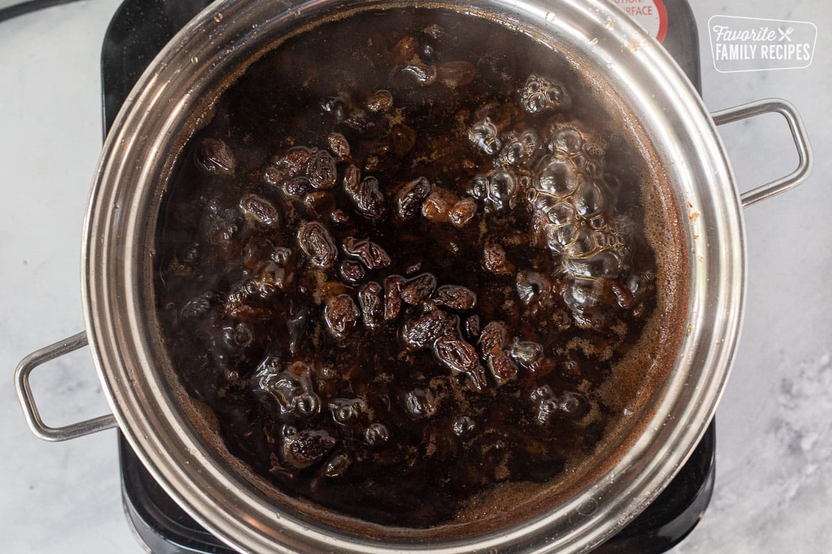 Saucepan with boiling raisins in water mixture.