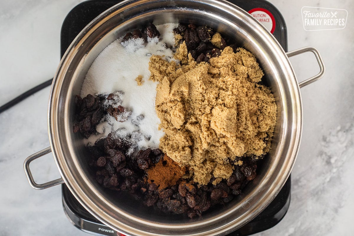 Saucepan with raisins, brown sugar, nutmeg and sugar.