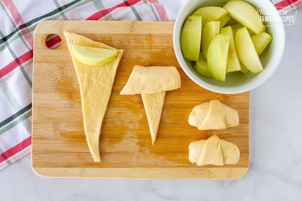 Cutting board with apples wrapping in crescent rolls for Apple Dumplings.