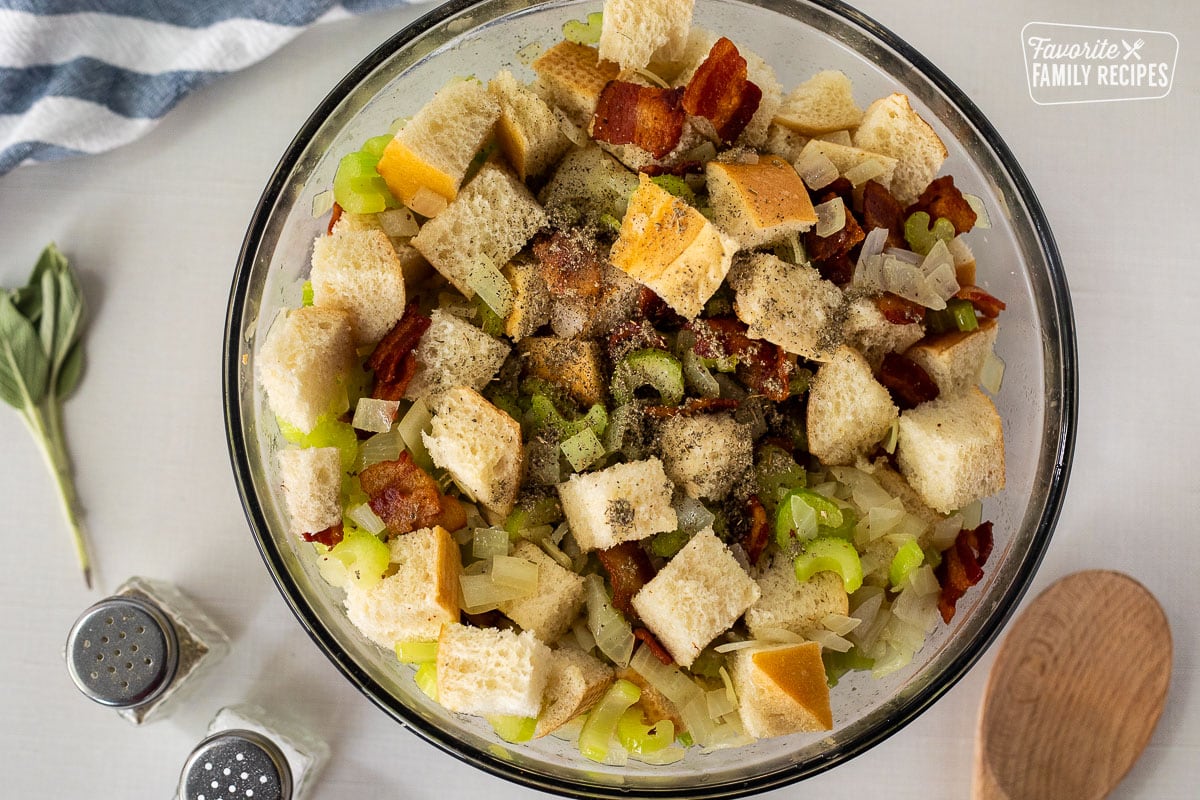 Seasoning on top of mixing bowl of bread, celery, onion and bacon.