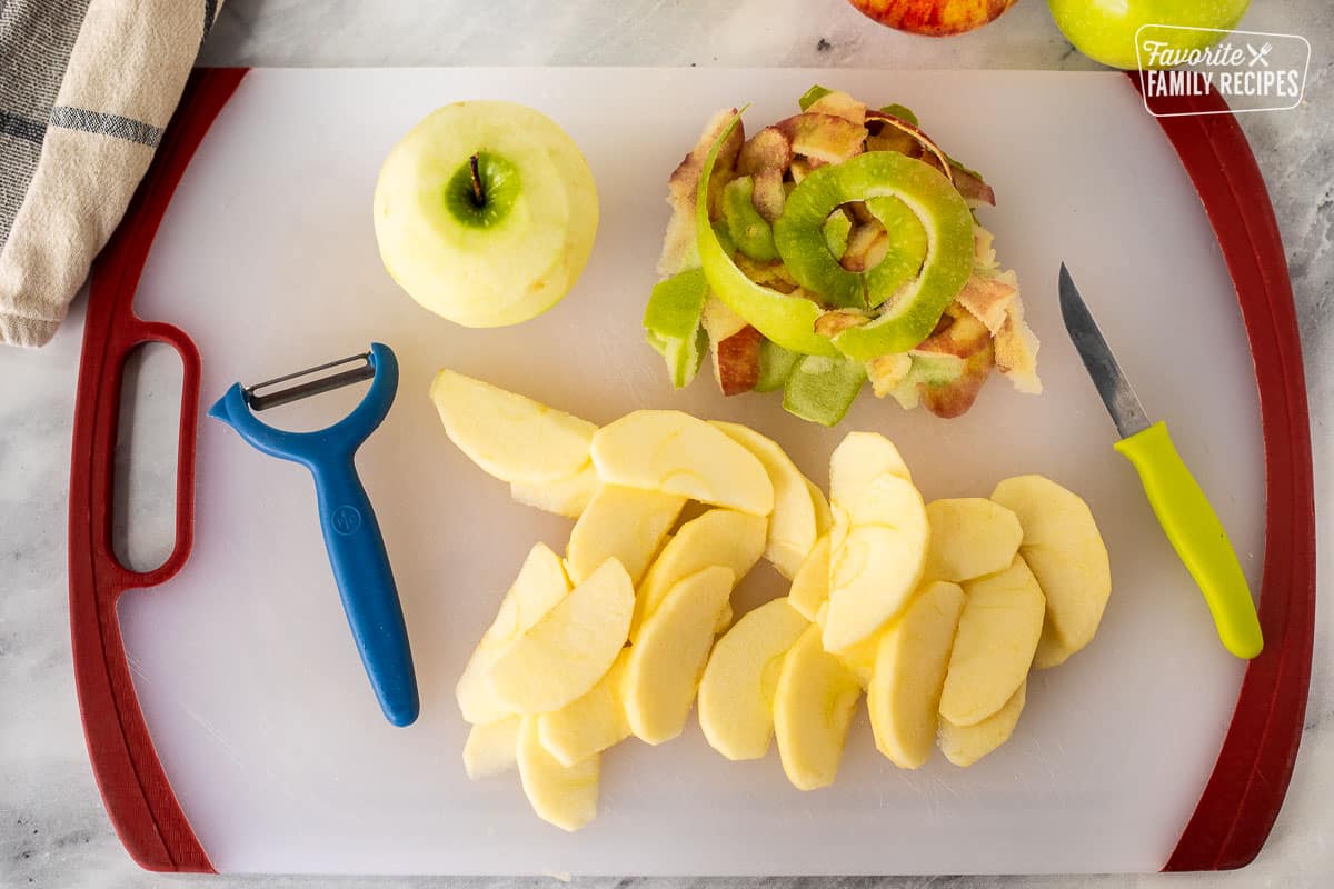 Cutting board with sliced apples for Apple Crisp.