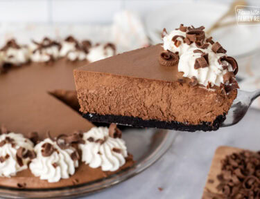 Holding a slice of Chocolate Satin Pie with pie spatula.