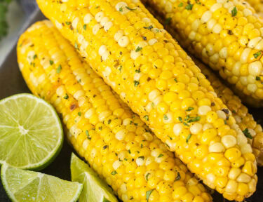 Grilled Corn on the Cob stacked on a platter.