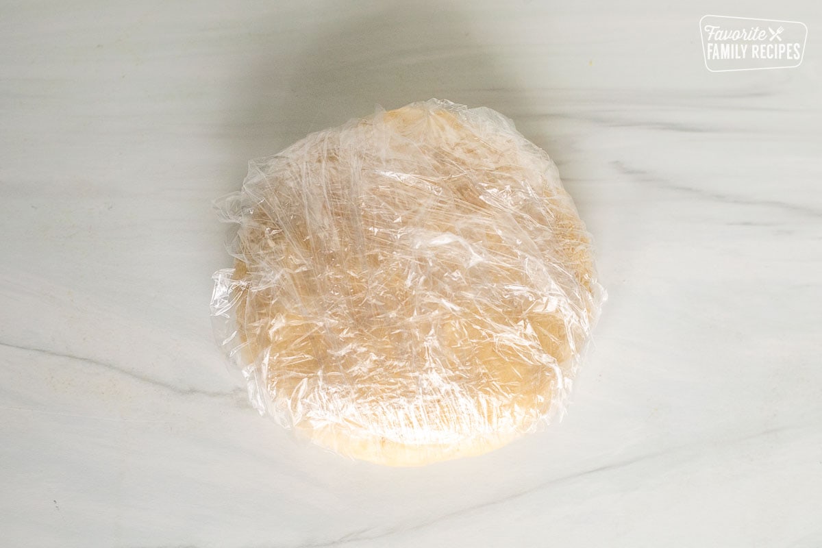 Pastry dough wrapped in plastic wrap.