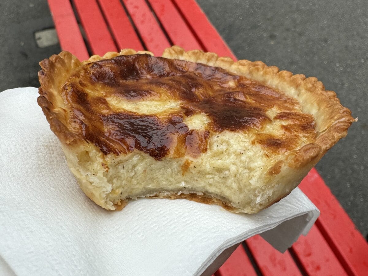 Cheese Pie from Chas Barmettler being held on a napkin showing the cheesy, gooey center