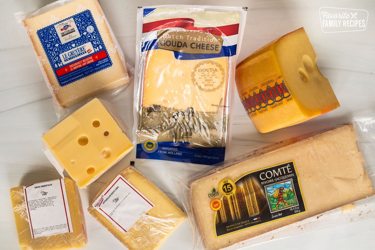 Different cuts of cheeses including gouda, Comte, appenzeller, Swiss emmentaler, Jarlsberg, gruyere.