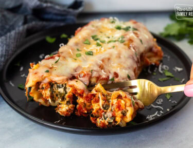 Cutting into a Chicken and Spinach Manicotti shell with a fork.