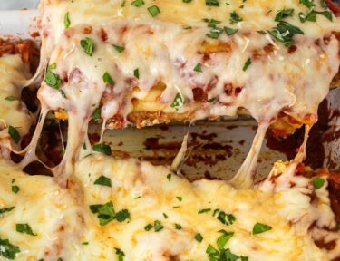 Lifting Chicken and Spinach Manicotti in a baking dish.