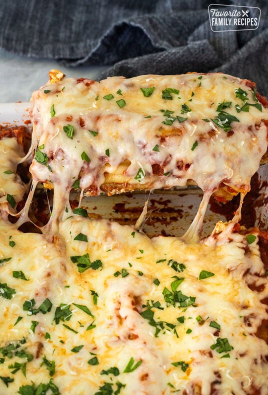 Lifting Chicken and Spinach Manicotti in a baking dish.