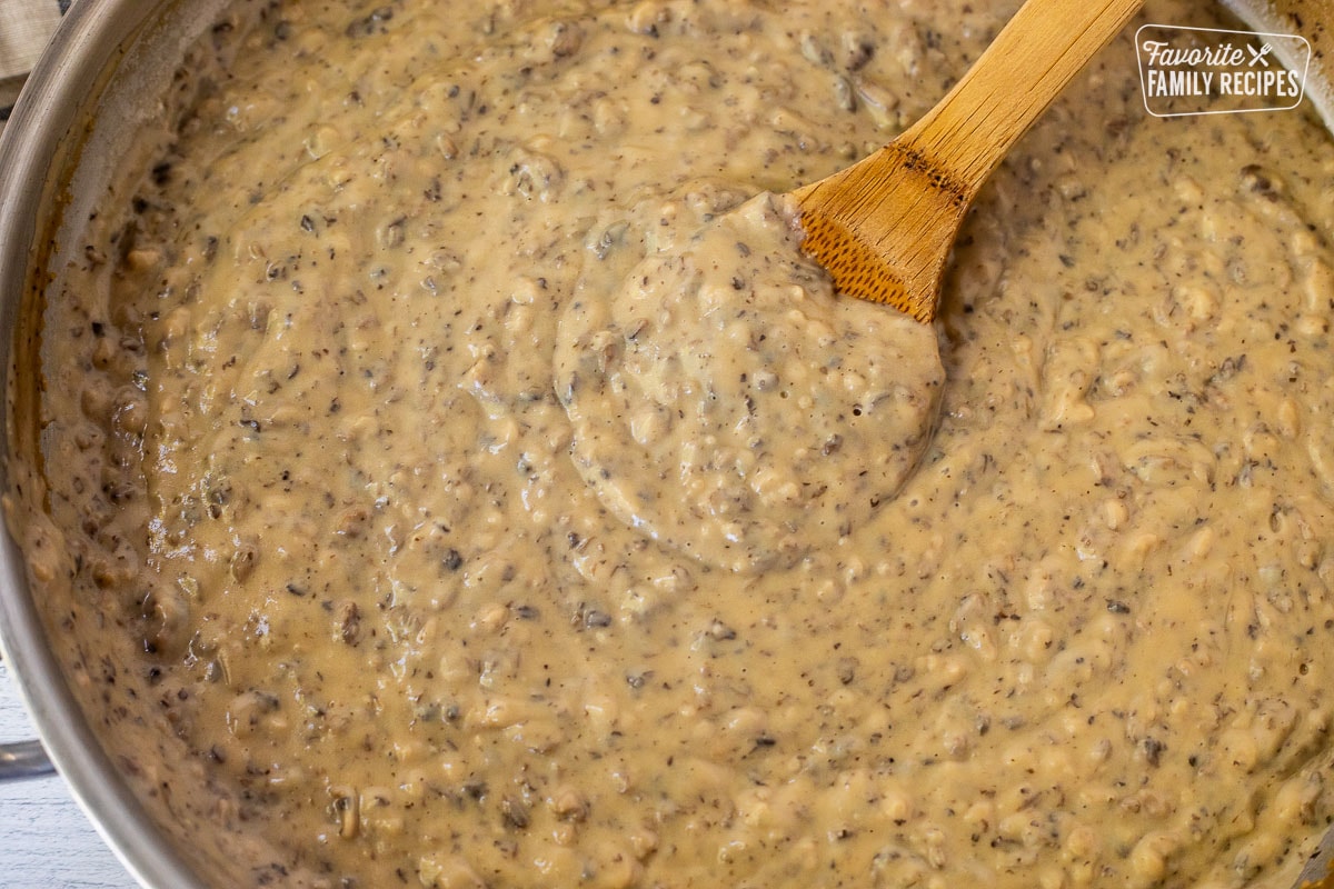 Skillet of Condensed Cream of Mushroom Soup and wooden spoon.