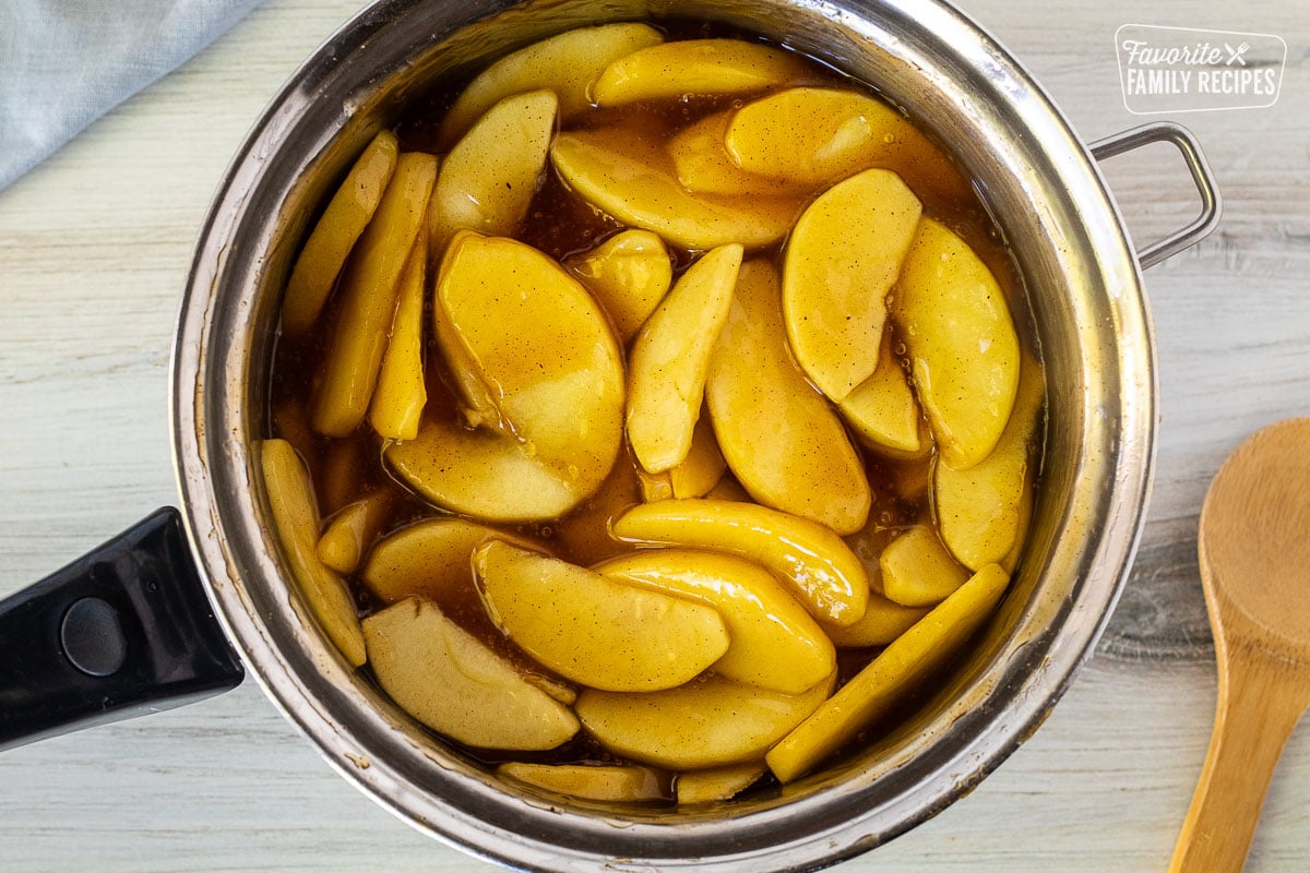 Pan of cooked Apple Pie filling. Wooden spoon on the side.