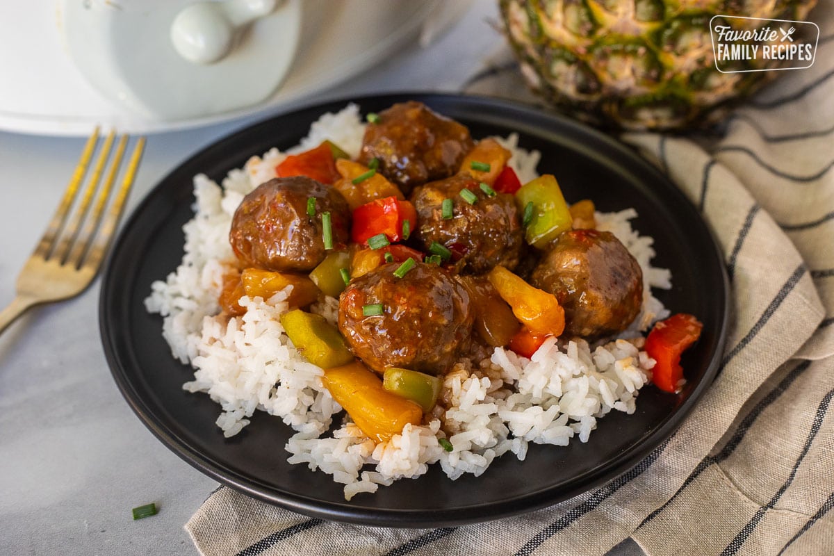 Plate of Crock pot of sweet and sour meatballs over rice.