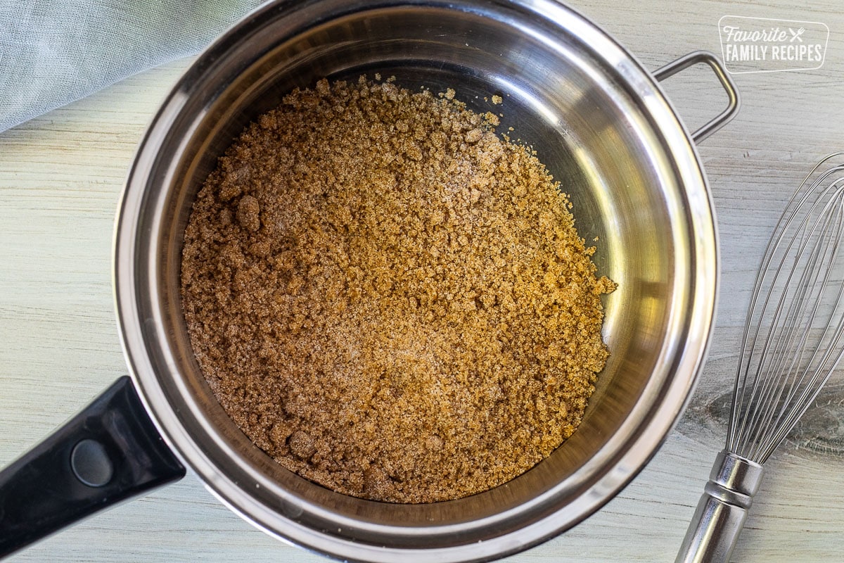 Pan with mixed dry ingredients for Apple Pie glaze next to a whisk.